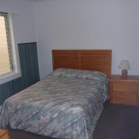 double bed in bedroom with window and nightstand with lamp