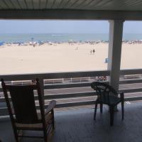 ocean and boardwalk view from balcony with rocking chair and plastic chair
