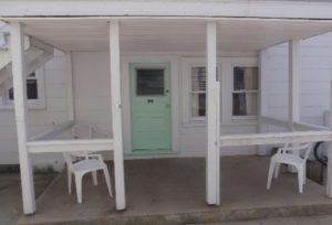 wood covered concrete apartment porch with chairs
