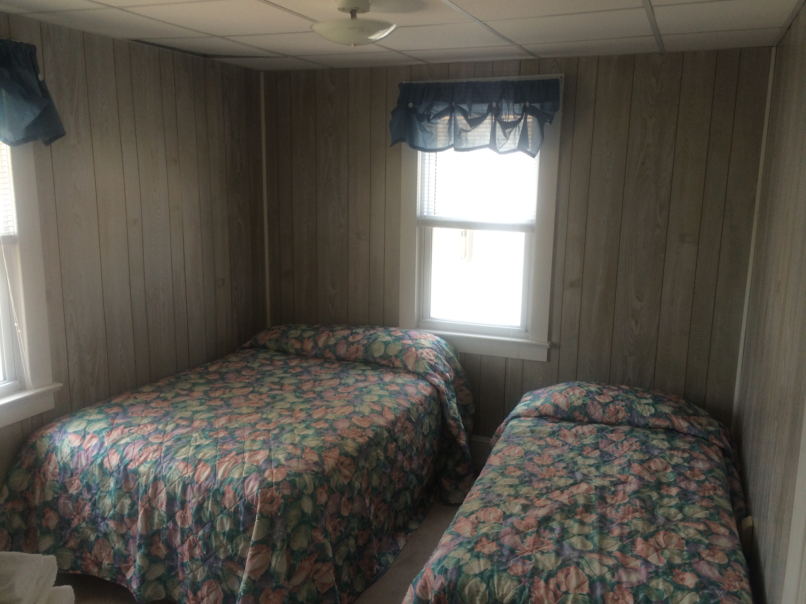 full size and single bed in bedroom with windows