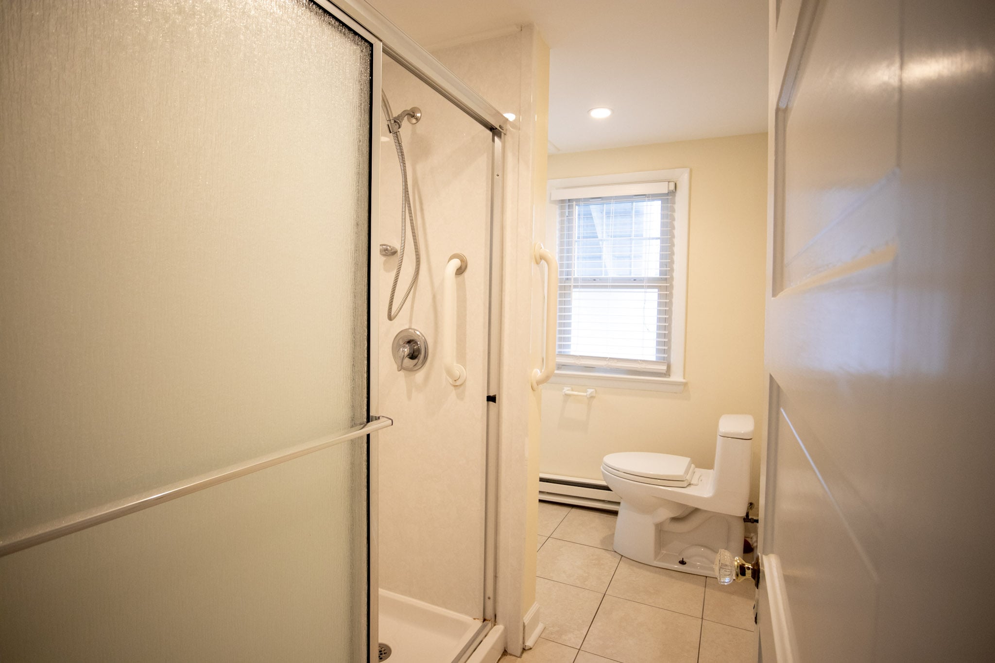 Spacious bathroom with white tile floors at the Majestic Hotel in Ocean City, Maryland